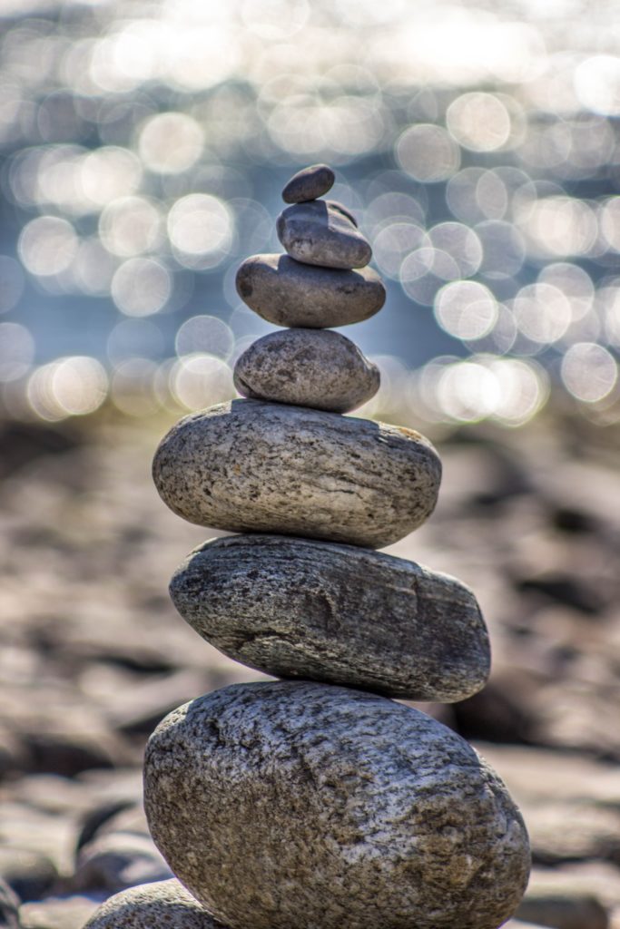 Se ve unas piedras en equilibrio con fondo de playa.